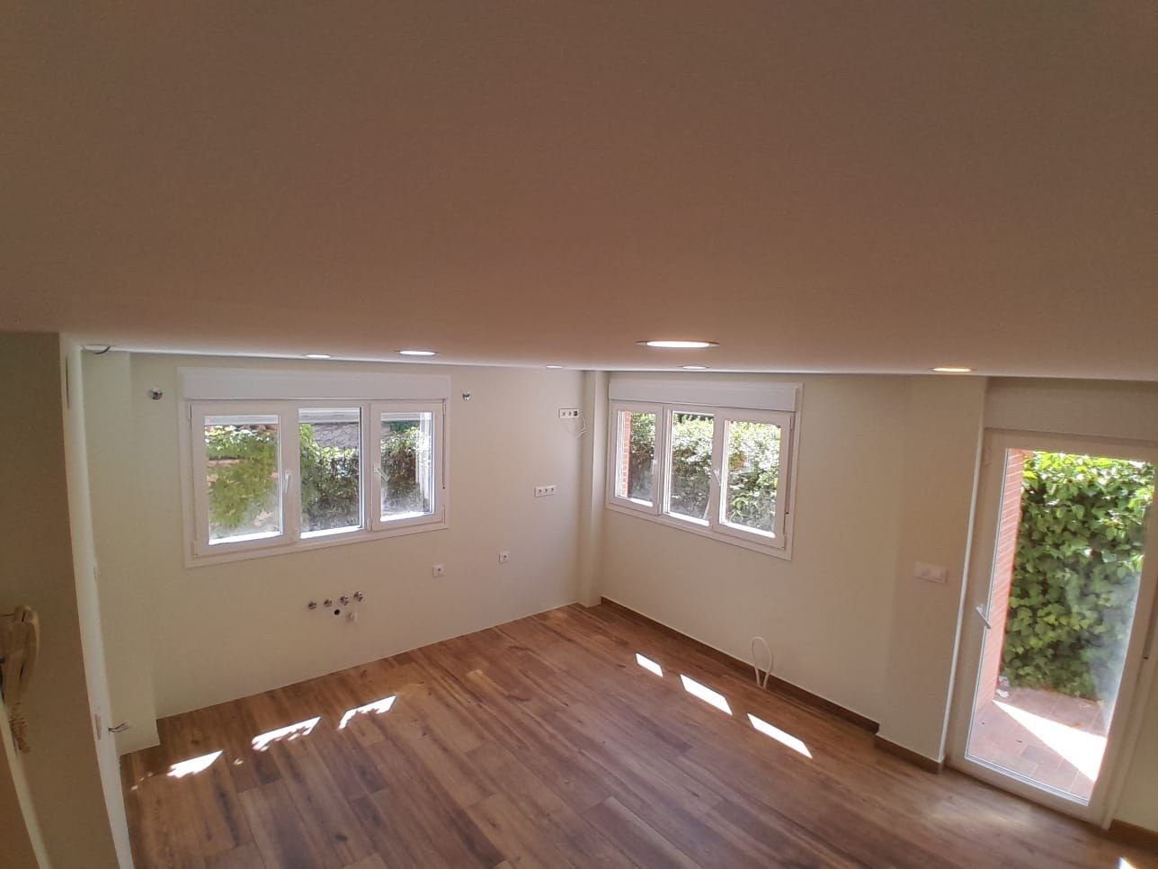 Estancia de chalet terminada, con suelo de madera y luz de tarde
