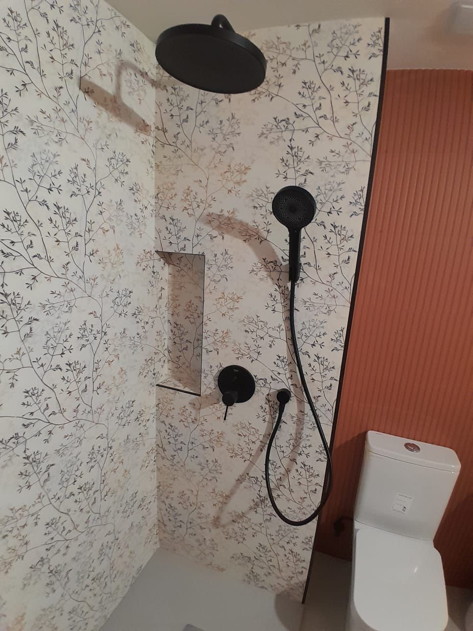Ducha con grifería negra y hornacina