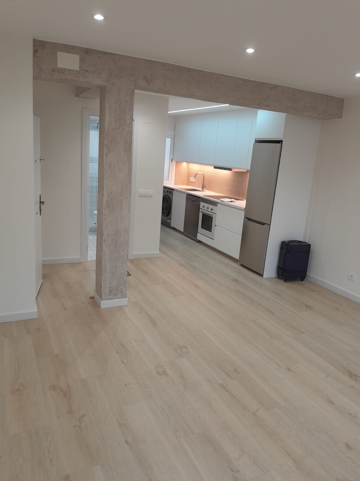 Salón-cocina con viga de madera vista