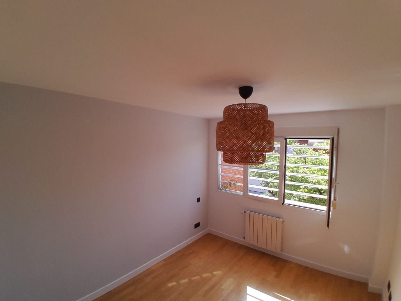 Dormitorio terminado con lámpara de ratán